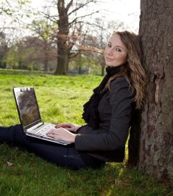 happy woman writing in park prayer answered