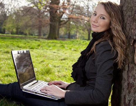 happy woman writing in park prayer answered